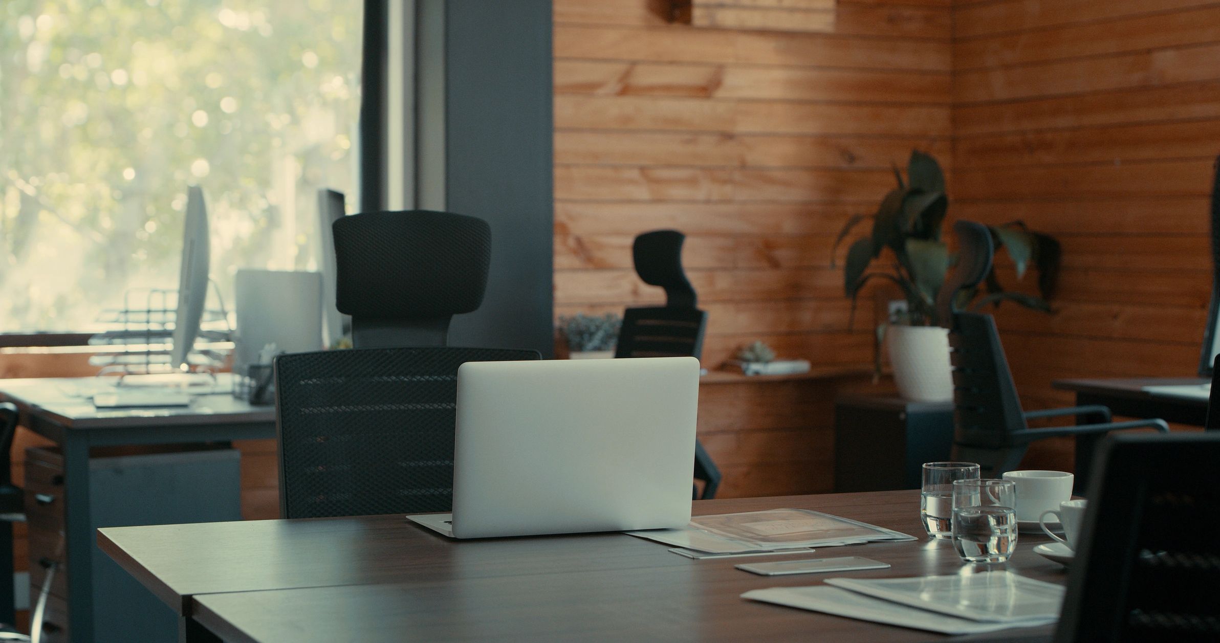 Minimal desk workspace with laptop and notebook in a calm, organized setting